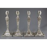 Two pairs of George III silver Adam style candlesticks, with tapering stems and engraved initials,
