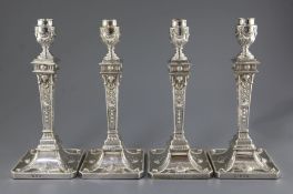 Two pairs of George III silver Adam style candlesticks, with tapering stems and engraved initials,