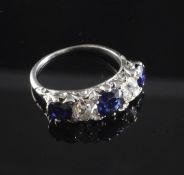 A 1920's/1930's white gold, sapphire and diamond graduated five stone half hoop ring, each diamond