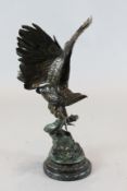 After Jules Moigniez (1835-1894). A bronze model of an eagle, perched upon a rocky outcrop, signed