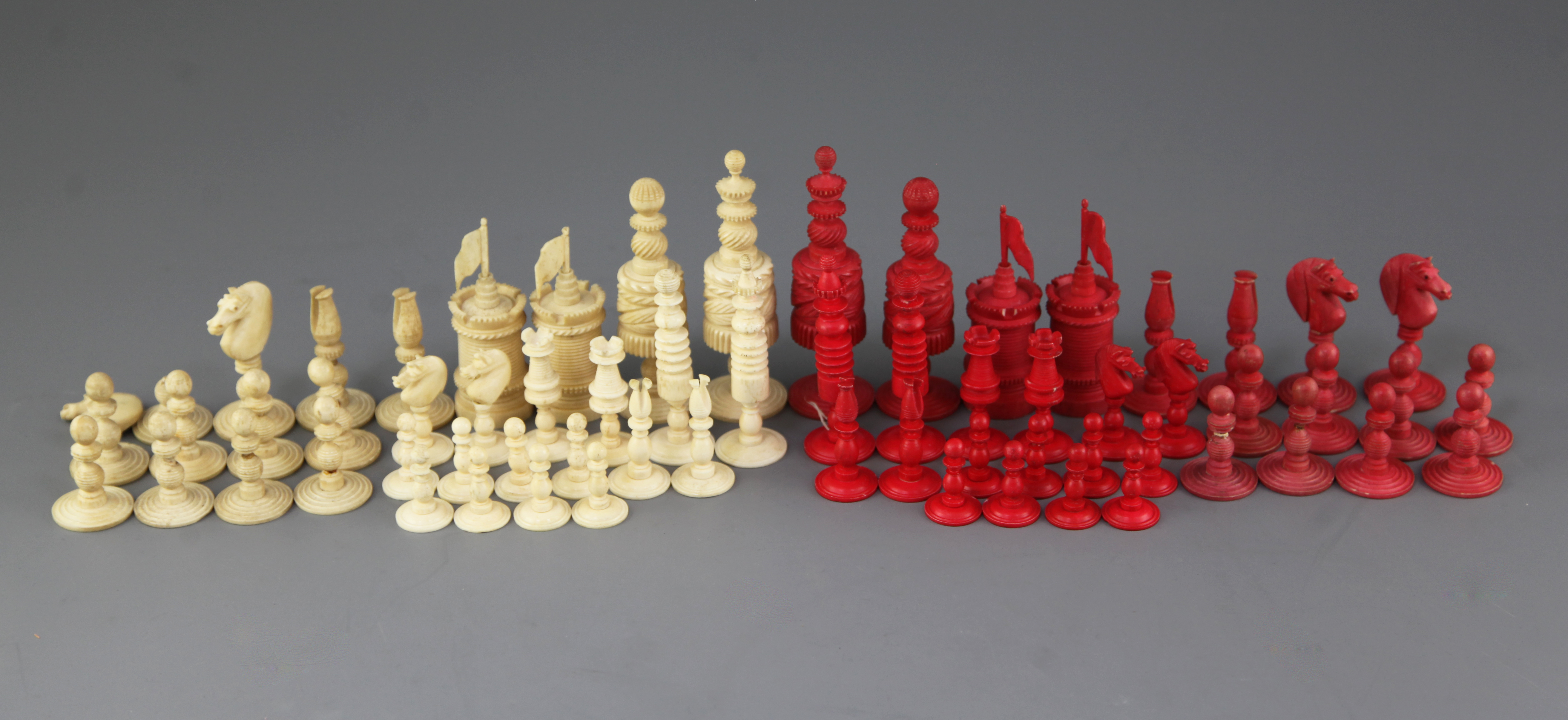 A 19th century Anglo Indian carved and stained bone chess set, kings 4.5in., and another similar