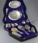 A cased George V thirteen piece engine turned silver dressing table set by Charles & Richard Comyns,