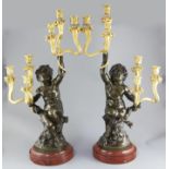 After Clodion. A pair of bronze and ormolu six light candelabra, with bacchic putto stems, signed in