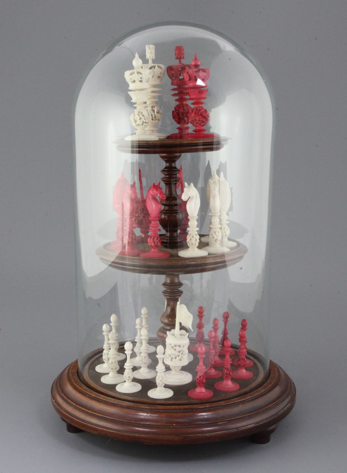 A 19th century Burmese carved and stained ivory chess set, kings 4in., with turned wooden display