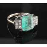 An Art Deco 18ct gold and platinum, emerald and diamond dress ring, the central emerald flanked by