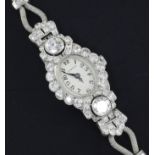 A lady's 1950's white gold and diamond set Vertex manual wind cocktail watch, with oval Arabic dial,
