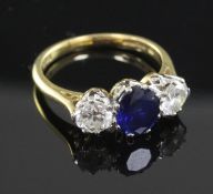 A 1980's 18ct gold three stone sapphire and diamond ring, size L.