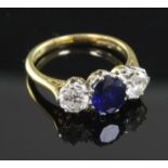 A 1980's 18ct gold three stone sapphire and diamond ring, size L.