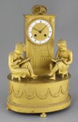 A French Empire ormolu mantel clock, modelled as a bookcase flanked by two children reading books,