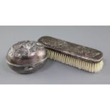 An early 20th century Japanese silver soap box and a clothes brush, both embossed with dragons,