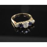 A late 19th/early 20th century gold and graduated five stone diamond and sapphire ring, size L.