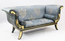 A Regency style parcel gilt green painted settee, with scroll ends and foliate decoration, W.6ft
