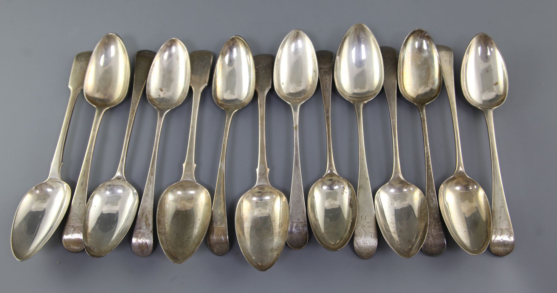 Fourteen assorted George III silver table spoons, various patterns, dates and makers, 30 oz.