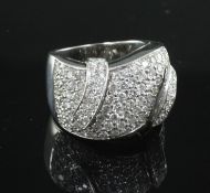 A white gold and diamond encrusted dress ring, with scroll motifs and an estimated total diamond