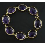 A gold and amethyst bracelet, set with eight double sided facet cut oval amethysts, approx 7.5in.