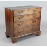 A George III mahogany chest, of four graduated long drawers, with original brass loop handles, on