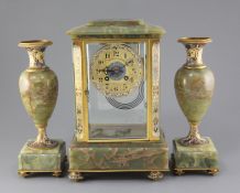 An early 20th century French ormolu mounted green onyx clock garniture, with champlevé enamel