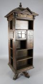 An early 20th century English Tabard Inn Library oak revolving bookcase of architectural design,