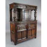 A 17th century style oak court cupboard, carved with foliate motifs and lions heads, W.4ft 3in. D.