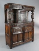 A 17th century style oak court cupboard, carved with foliate motifs and lions heads, W.4ft 3in. D.