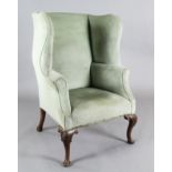 An early 18th century style mahogany wing armchair, with shell knee cabriole legs, W.2ft 7in. H.