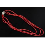 A triple strand coral bead necklace with marcasite set silver clasp, 22in.
