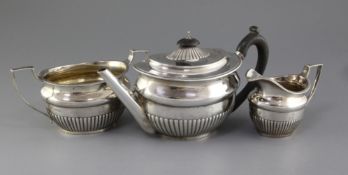 A Victorian three piece demi-fluted silver oval tea set by Stephen Smith, with engraved armorial,