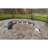 A large composition stone horseshoe garden bench comprising four curved slab seats having egg & dart