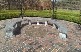 A large composition stone horseshoe garden bench comprising four curved slab seats having egg & dart