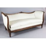 A Louis XVI style walnut serpentine settee, the show-wood frame carved with ribbon scrolls and