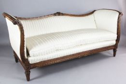 A Louis XVI style walnut serpentine settee, the show-wood frame carved with ribbon scrolls and