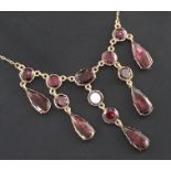 A Victorian gold and garnet drop necklace, set with fourteen garnets in a closed back setting,