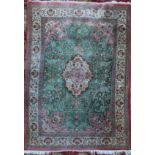 An Isphahan style silk rug, with central foliate medallion in a field of scrolling foliage, on a