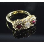 An 18ct gold ruby and diamond triple cluster ring, size K.