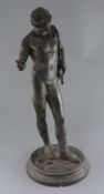 After the Antique. A Grand Tour bronze figure of Narcissus, standing on an integral circular plinth,