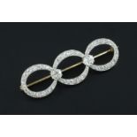 A gold, platinum and diamond triple loop brooch, set with fifty six graduated round cut stones and