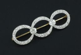 A gold, platinum and diamond triple loop brooch, set with fifty six graduated round cut stones and