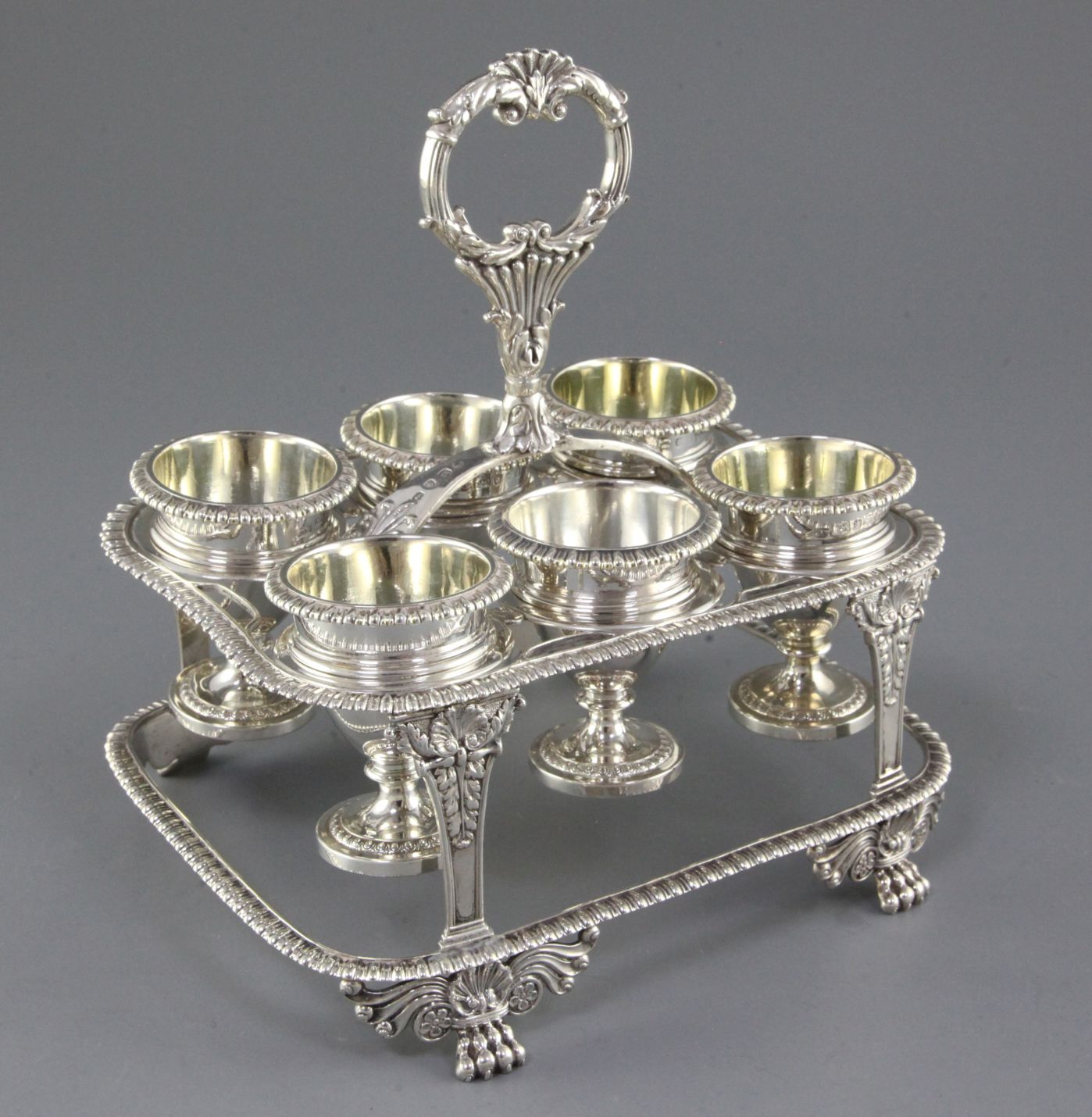 A George III silver egg cruet by William Elliott, of rectangular form, with six cups, engraved