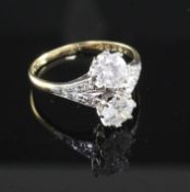 An 18ct gold and platinum, two stone diamond ring with diamond set shoulders, the two round