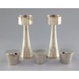 A pair of 1970's silver candle holders and a three piece silver condiment set by Graham Watling of