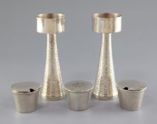 A pair of 1970's silver candle holders and a three piece silver condiment set by Graham Watling of