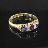 A Victorian 18ct gold, three stone sapphire and four stone diamond set ring, size N.