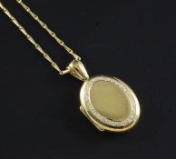 A 1990's Mappin & Webb 18ct gold and diamond oval locket on an 18ct gold chain, locket 1.25in inc.