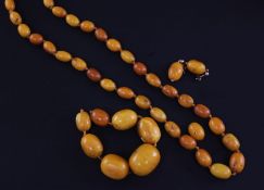 A single strand graduated oval amber bead necklace together with eight other beads and a pair of