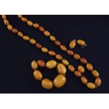 A single strand graduated oval amber bead necklace together with eight other beads and a pair of