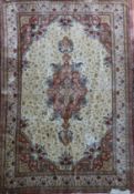 An Isphahan style silk carpet, with central foliate medallion in a field of scrolling foliage, on an