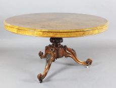 A Victorian burr walnut breakfast table, with circular tilt top, on floral carved tripod base and