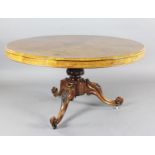 A Victorian burr walnut breakfast table, with circular tilt top, on floral carved tripod base and