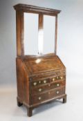 An early 18th century walnut bureau bookcase, with two glazed doors over a fall enclosing a well,