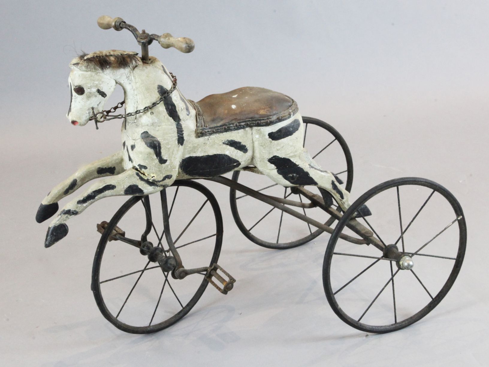 A 19th century French wrought iron and carved and painted velocipede modelled as a horse, overall